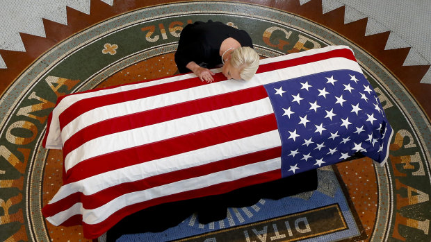 John McCain's wife, Cindy, lays her head on the casket of her husband during a memorial service at the Arizona Capitol on Wednesday.