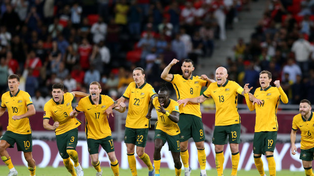 Andrew Redmayne’s Socceroos teammates celebrate after the keeper’s crucial save in Doha.