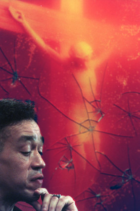Andres Serrano with his controversial work "Piss Christ", which was attacked by a protester.