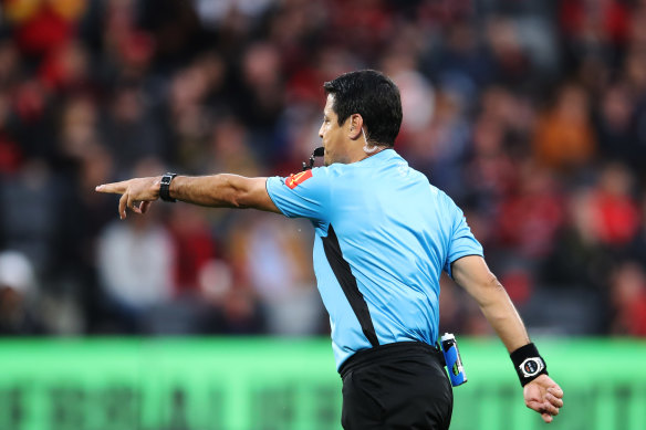Referee Alireza Faghani points to the penalty spot after reviewing a hand-ball with VAR earlier this season.