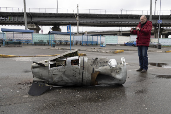 A man takes a photo of the remains of a missile in a street in the Vydubychi district of Kyiv, Ukraine. Russian forces have shelled Europe’s largest nuclear power plant. 