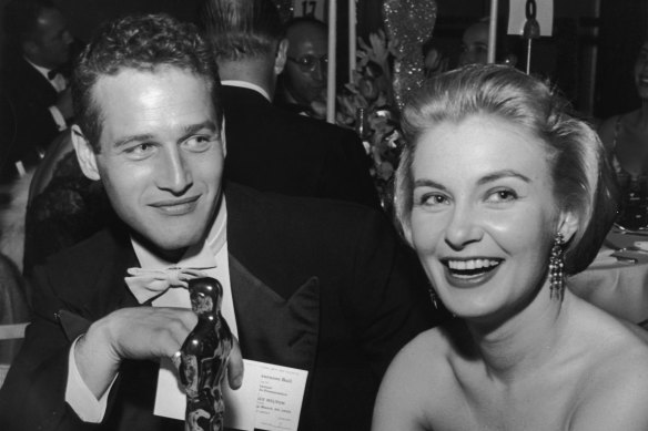Joanne Woodward holds her Oscar statuette while sitting next to husband Paul Newman in 1958.