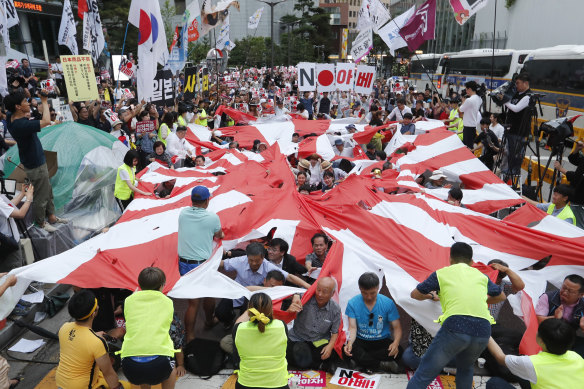 Protesters tear a Japanese rising sun flag during a rally denouncing a Japanese government’s export decision in Seoul, South Korea.
