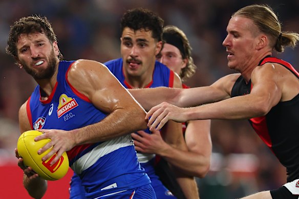 Marcus Bontempelli breaks a tackle attempt.