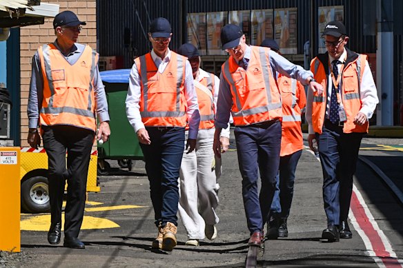 Balancing act: Premier Chris Minns walks along a rail at the Flemington train maintenance yards on Thursday.