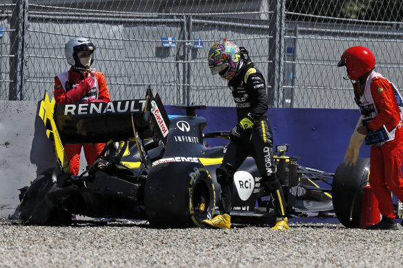 Daniel Ricciardo walks away from his Renault after crashing into the barriers during the second practice session on Friday