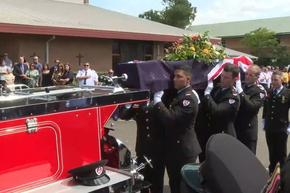 Michael Kidd’s casket arrives at the service in a vintage fire truck. 
