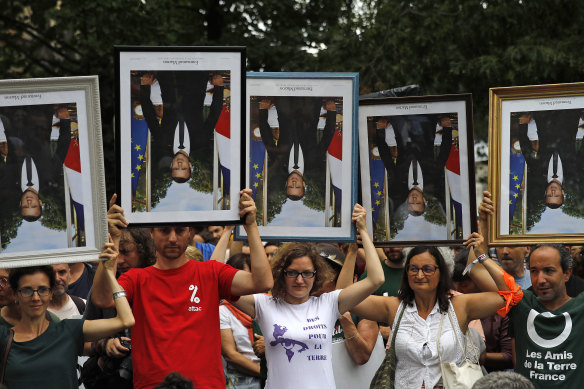 Protesters in Bayonne, south-west France,  hold upside down portraits of President Emmanuel Macron. The portraits have been removed from town halls by activists.