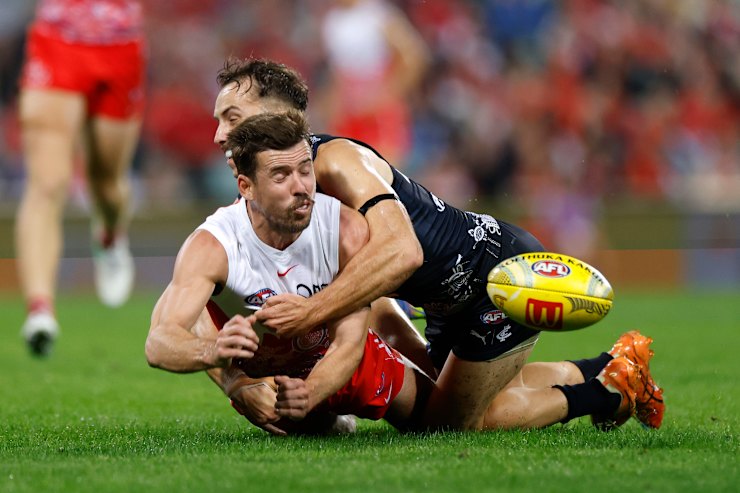 Francis Evans of Carlton tackles Jake Lloyd of the Swans.