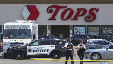 Police walk outside the Tops grocery store on Sunday after the shooting in Buffalo, New York.