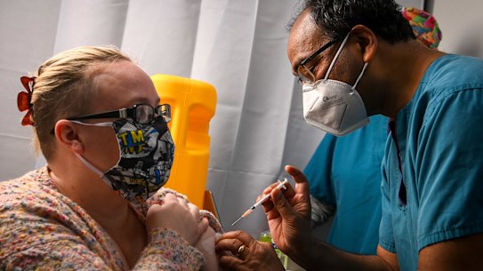 GP Mukesh Haikerwal administers a dose of Pfizer to Amanda Ashton.