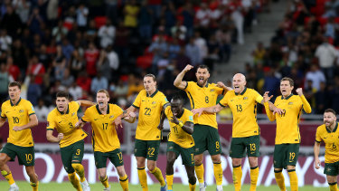 Andrew Redmayne’s Socceroos teammates celebrate after the keeper’s crucial save in Doha.
