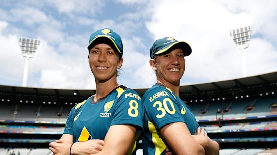Erin Burns and Delissa Kimmince pose at training on Saturday, their shirts bearing the names of injured teammates Ellyse Perry and Tayla Vlaeminck.