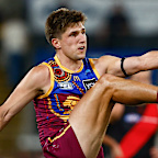 Zac Bailey of the Lions kicks a goal.