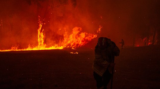 Firefighters undertake property protection as a bushfire impacts property in Mangrove Mountain on December 5.