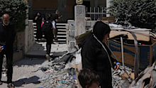 Residents walk past debris outside Jabal Amel Hospital, which was heavily damaged in Israeli strikes that hit nearby buildings earlier this month,