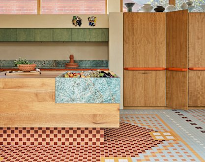 The kitchen island bench, a combination of timber and turquoise quartzite, forms the heart of the new wing.