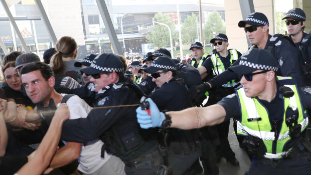 Police use pepper spray as protesters attempt to stop conference members entering the conference. 