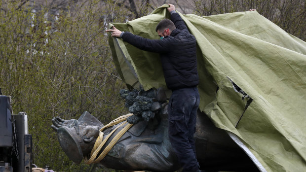 A worker covers the statue of a Soviet World War II commander after it was removed from its site in Prague.