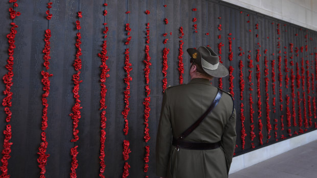 A man in uniform walks along the Roll of Honour at the Australian War Memorial.