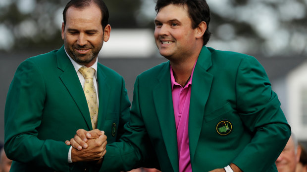 Good fit: Reed receives his green jacket from last year's winner, Sergio Garcia.