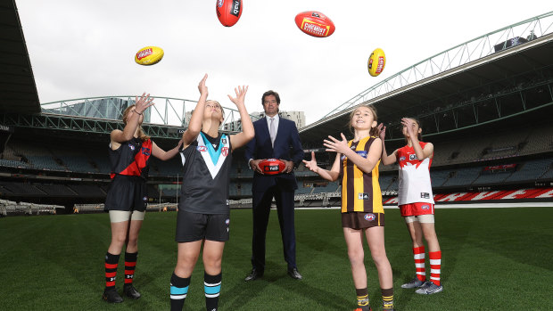 AFL chief Gillon Mclachlan poses with young footballers Nora Don, Fadilla Taleb, Leni Burgoyne and Layla Rabah.