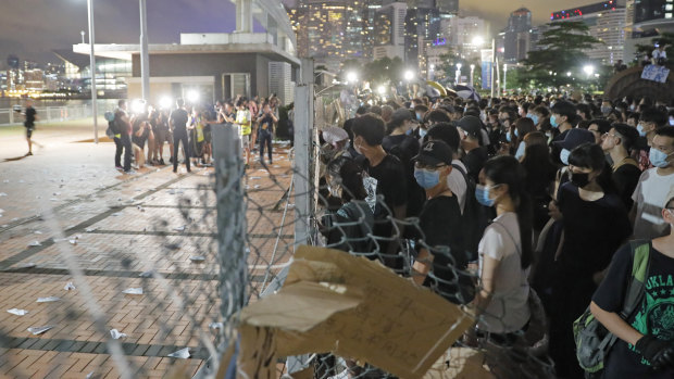 Anti-extradition bill protesters try to walk across the fence at the Central Waterfront in Hong Kong on Saturday.
