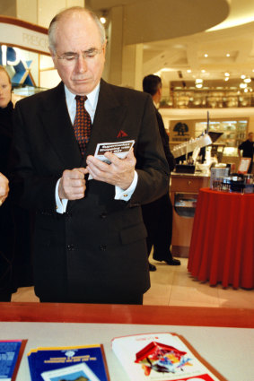 The PM examines a pamhplet on how to shop with the GST on July 1, 2000