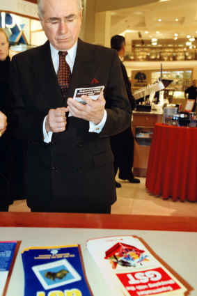 Then-Prime Minister John Howard examines a pamphlet on how to shop with the GST on July 1, 2000.