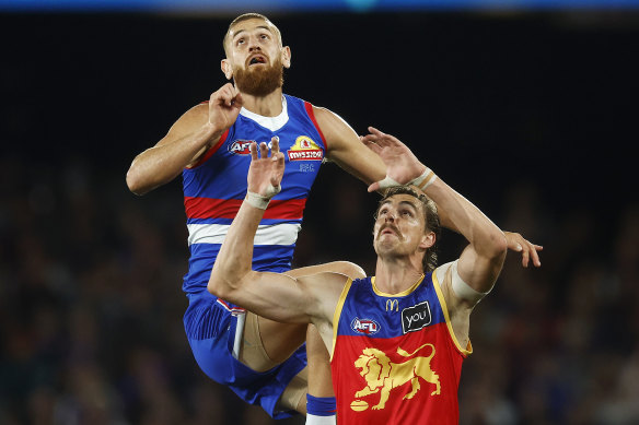 Liam Jones of the Bulldogs and Joe Daniher of the Lions contest for the ball.