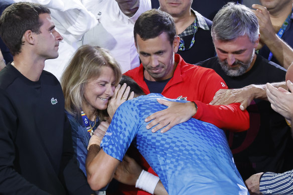 Novak Djokovic embraced by his box.