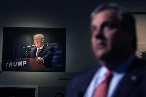 A photograph of former president Donald Trump hangs on the wall as Republican presidential candidate Chris Christie listens to a question during a gathering on Tuesday (US time).