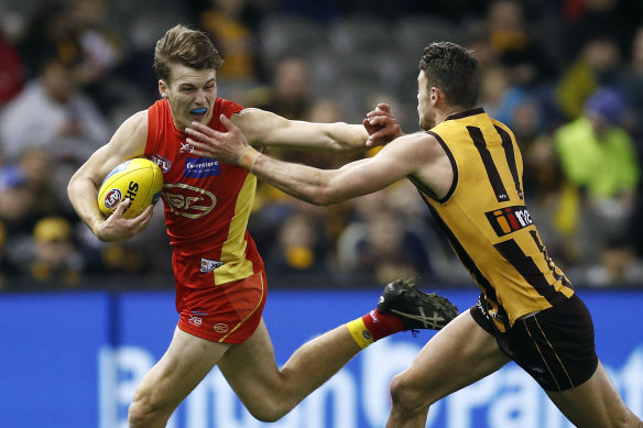 Gold Coast's Charlie Ballard fends off a tackle.