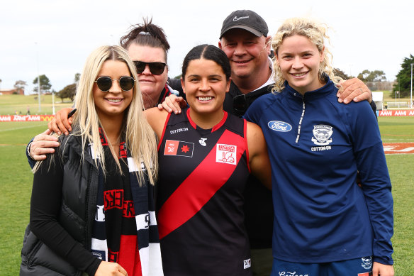 Madison Prespakis of the Bombers and Georgie Prespakis of the Cats pose with family members after the teams clashed.