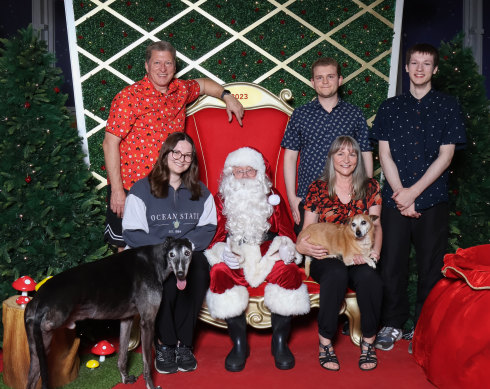 Santa photographer Catherine Ward (bottom left) with greyhound Cody, poses in her family’s Santa photo at Westfield Knox shopping centre. With her father Jeff, mum Karen (holding Jack Russell terrier cross Tyson), and brothers Leighton and Daniel.