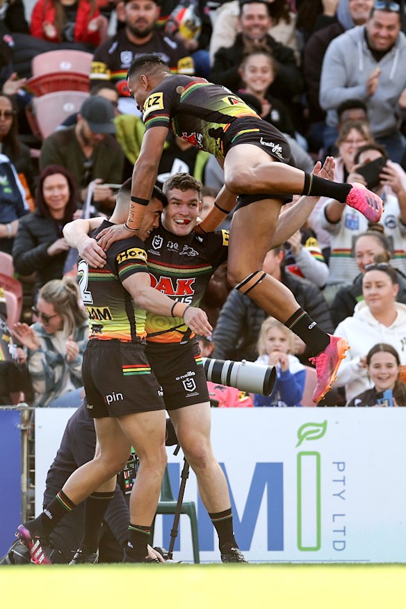 Charlie Staines is mobbed by teammates after his score for the Panthers.