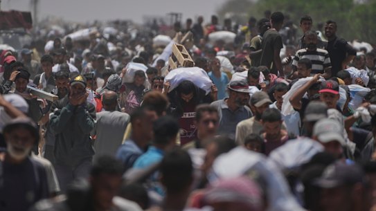 Palestinians carry bags containing food and humanitarian aid packages delivered by the Gaza Humanitarian Foundation in Rafah.