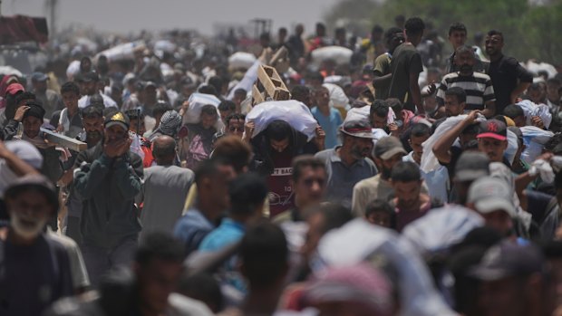 Palestinians carry bags containing food and humanitarian aid packages delivered by the Gaza Humanitarian Foundation in Rafah.