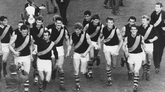Led by captain Fred Swift, the victorious Richmond team runs a lap of honour after winning the 1967 premiership. 