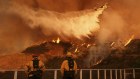 Firefighters watch as water is dropped on the Palisades Fire in Mandeville Canyon.