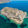 The remains of a Venetian fortress and Ottoman-era houses against a blue sea are bizarrely picturesque in Spinalonga.