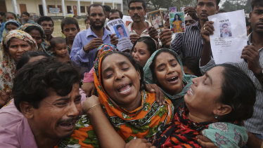 Bangladeshi relatives of garment worker Mohammed Abdullah cry as they as they arrive to collect his body at a makeshift morgue in a schoolyard near a building that collapsed in Savar, near Dhaka, Bangladesh in 2013.