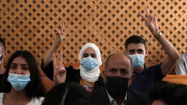 Palestinian residents of Sheikh Jarrah in Jerusalem flash the victory sign prior to the hearing at the Supreme Court in Jerusalem.
