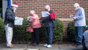 People wait in line on the first day of advance voting for Georgia's two Senate runoff elections.