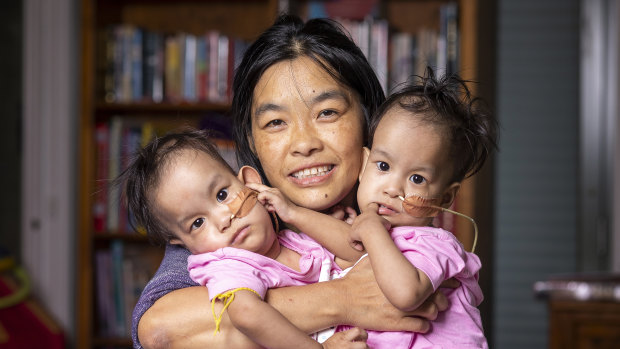 Bhumchu Zangmo hugs her twin girls Nima and Dawa.