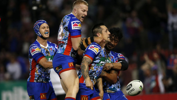 Pumped: Mitchell Pearce is mobbed after scoring against the Roosters.