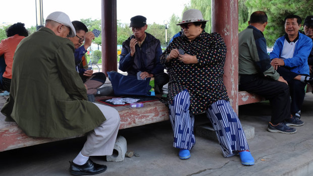 Tumen residents play cards in a park on the border with North Korea on Friday.