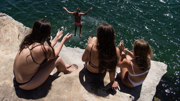 Swimmers jump off the rocks at Neilson Park to beat the heat.