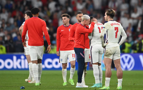 England’s Phil Foden consoles teammate Jadon Sancho after he misses the side’s fourth penalty