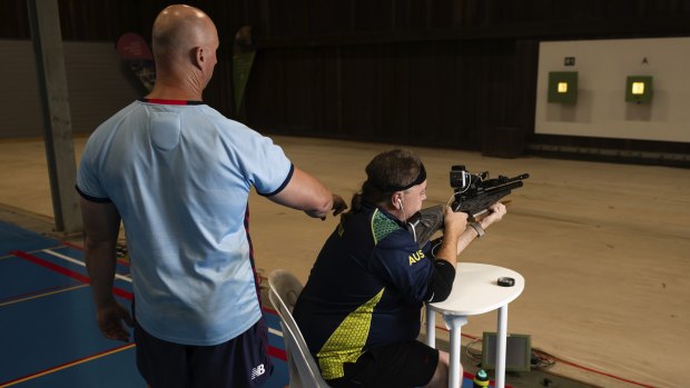 King practises at the Sydney International Shooting Centre, accompanied by a support worker.
